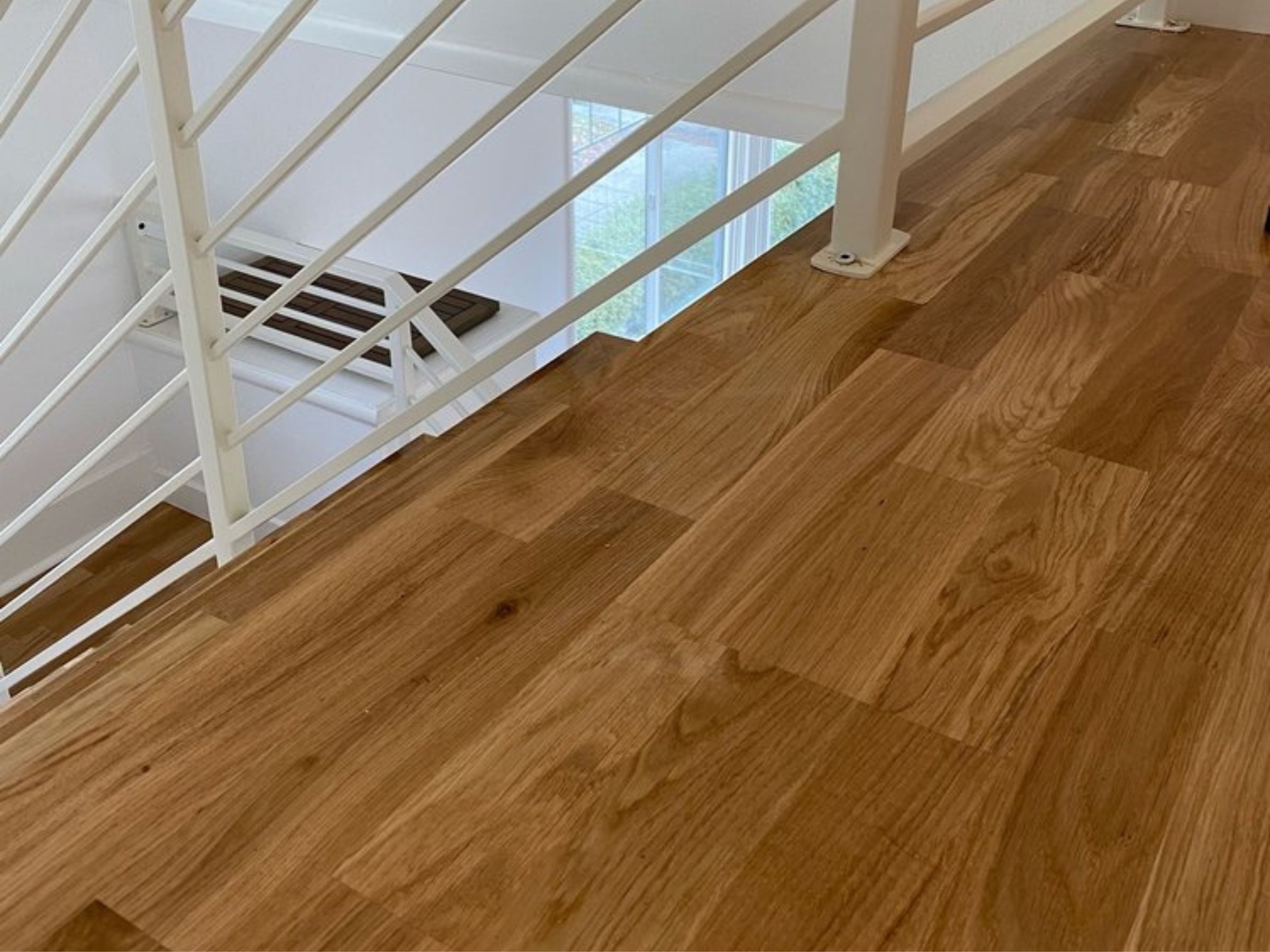 Bellevue hardwood floor refinishing project with 2.25 inch white oak on main level and wide-plank engineered hardwood upstairs by LUKS Construction